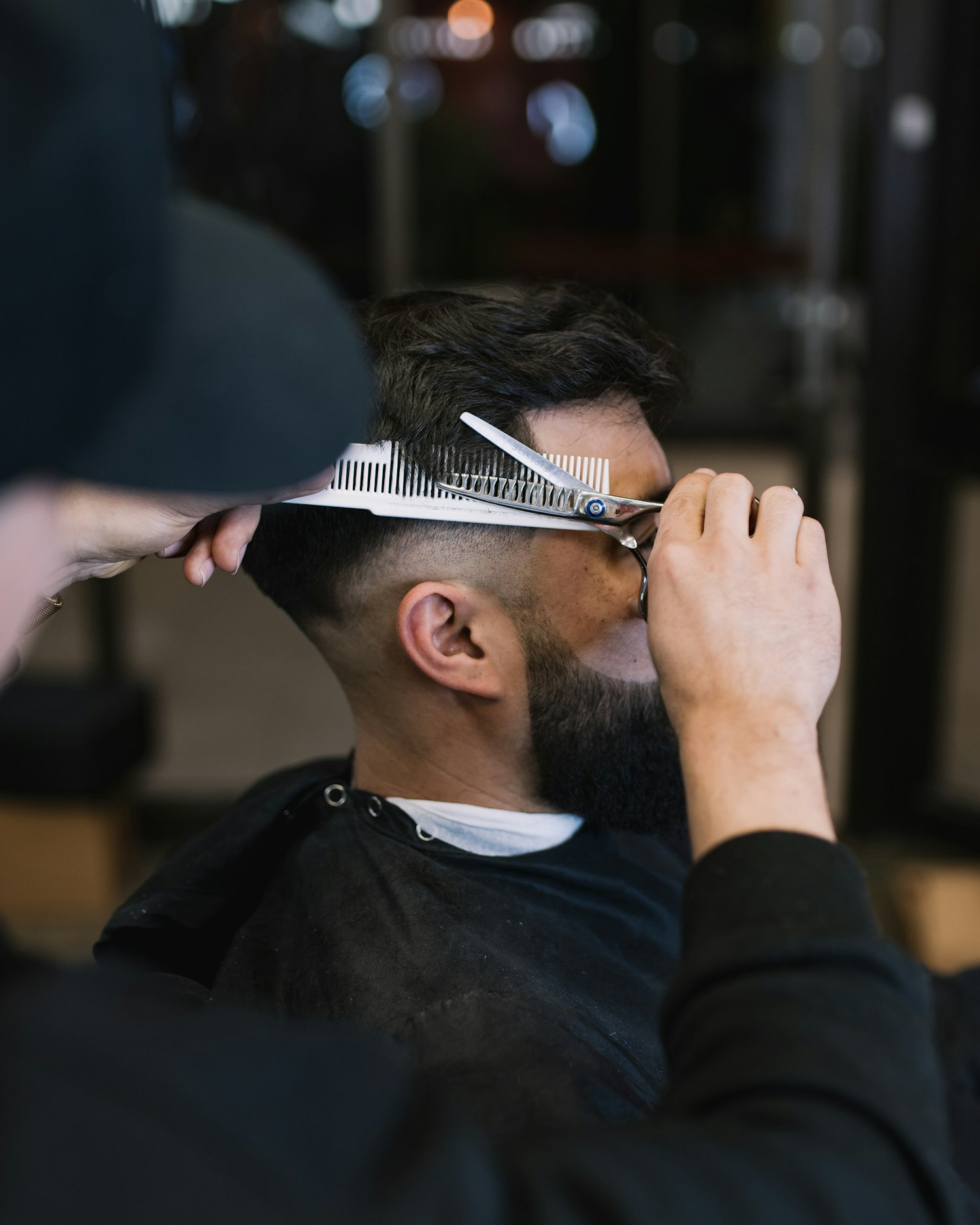 Barbier knipt haar met schaar en kam