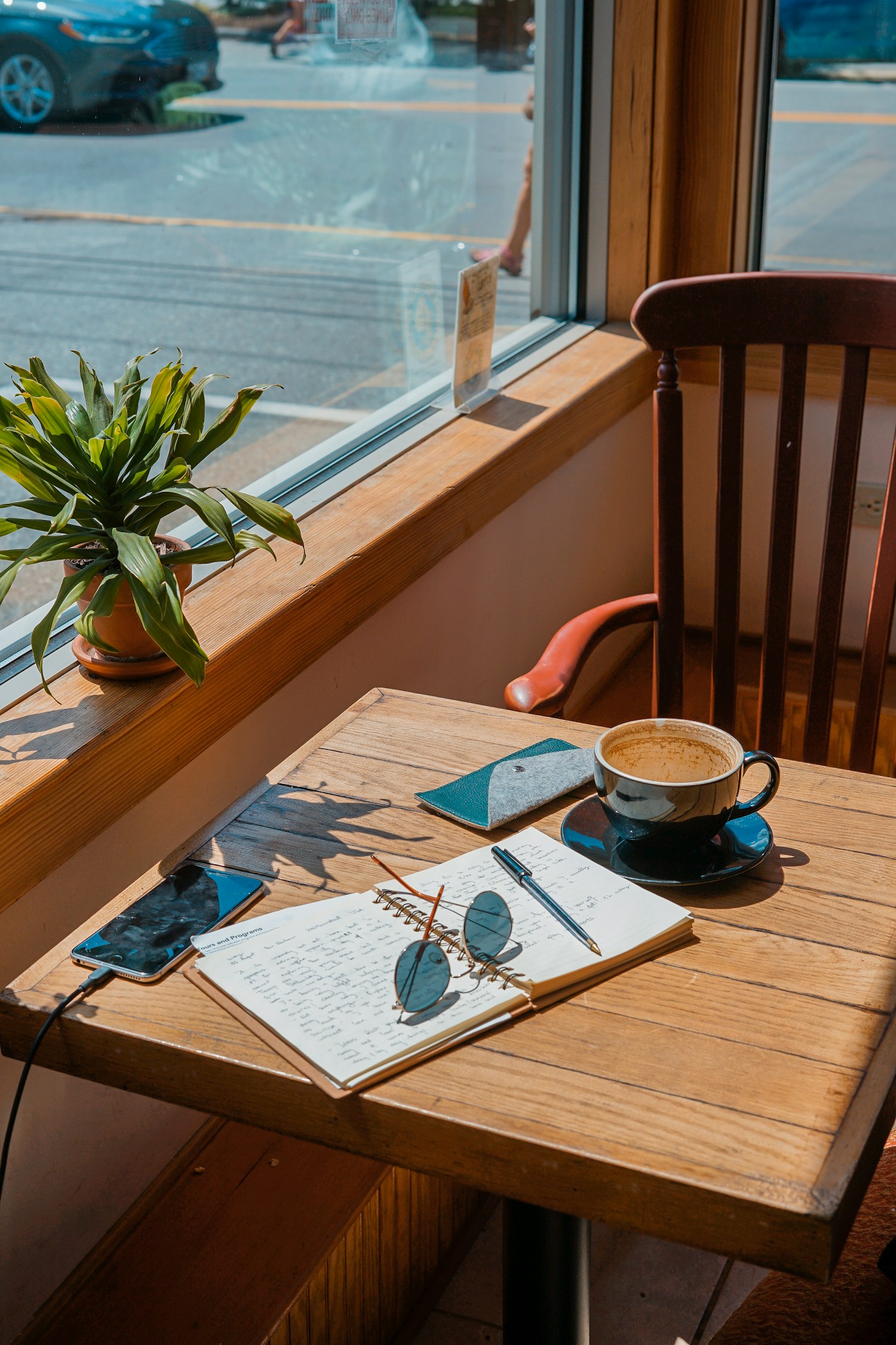 Zonnig plekje bij het raam met koffie en een notitieboek